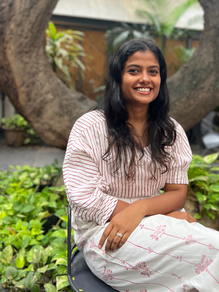 A young Indian woman sitting outdoors. Photo.