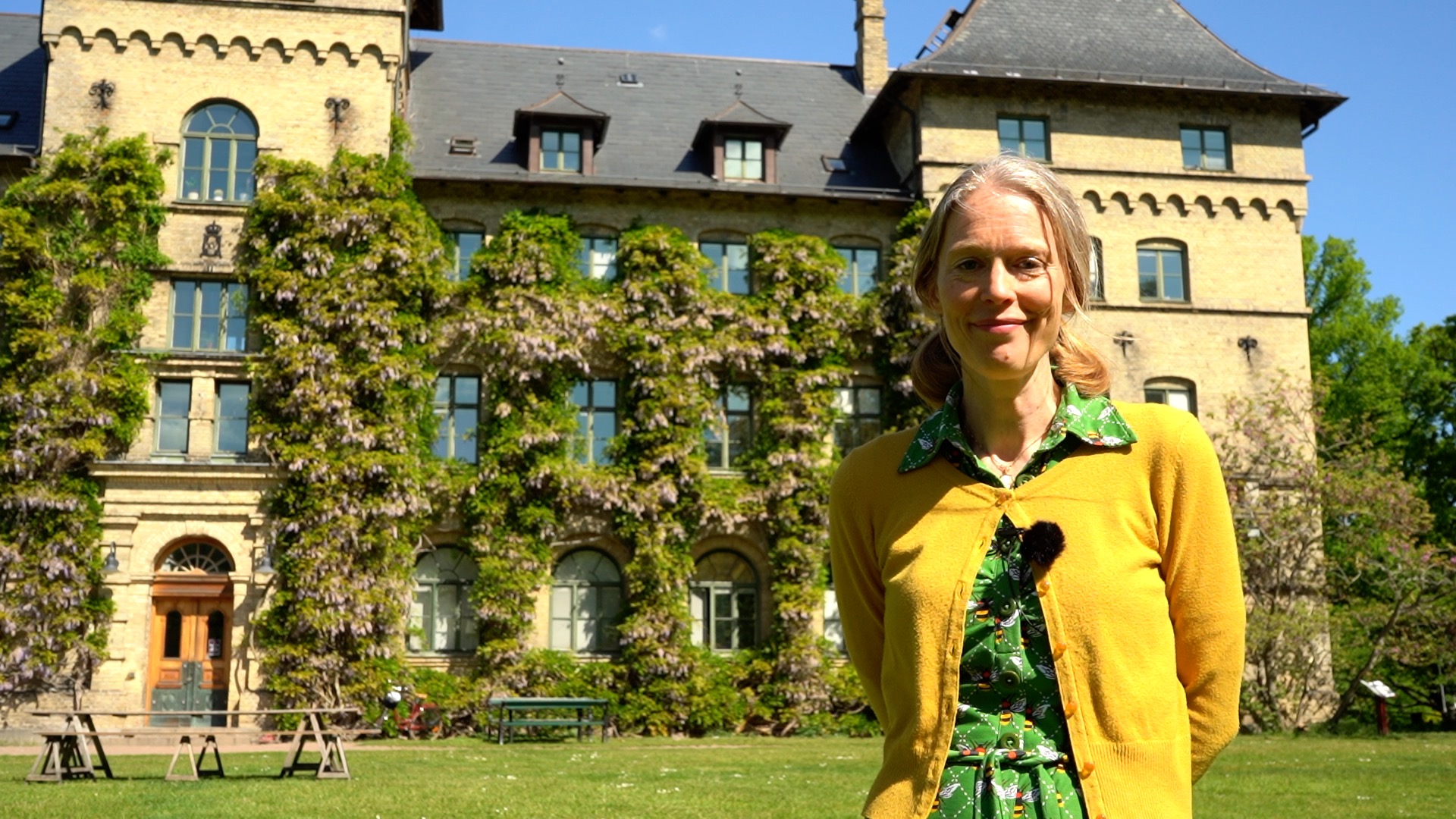 En leende kvinna framför ett slott