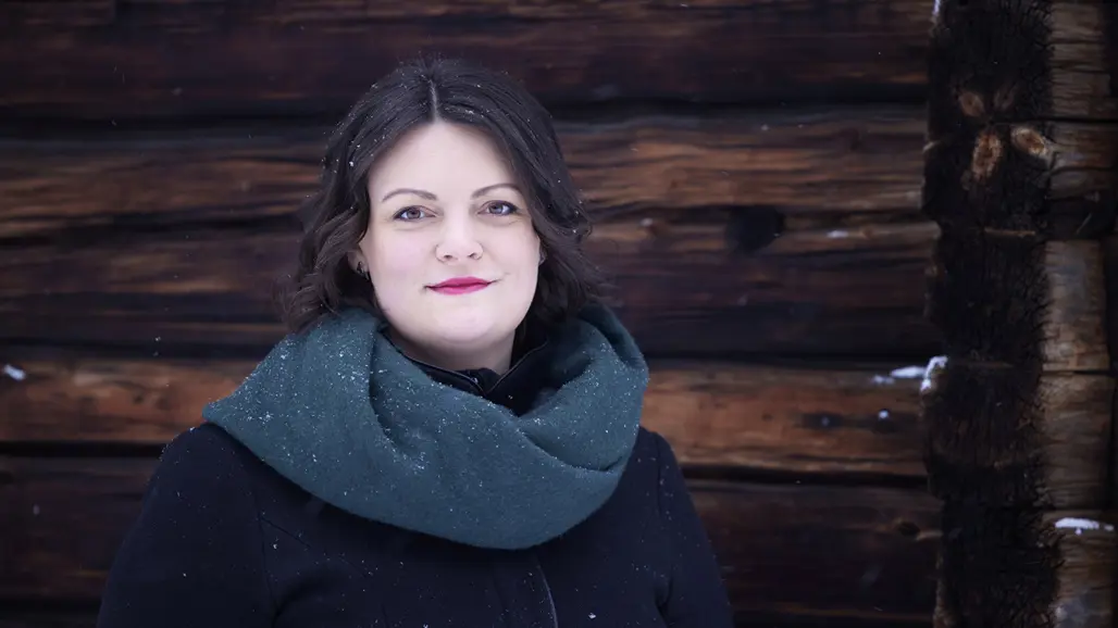 Porträtt av Isabella Hallberg-Sramek framför en trävägg
