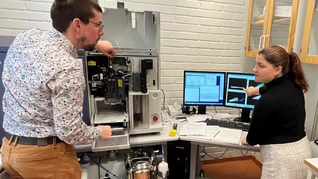 Vladimír Skalický and Ioanna Antoniadi stand in front of the cell sorting machine and look into the camera.