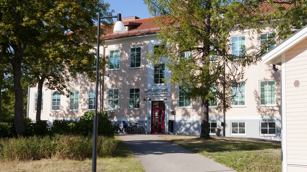 Kustlaboratoriets byggnad i Öregrund. En byggnad med ljusrosa fasad fotograferad en solig sommardag.
