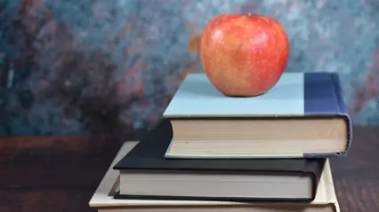 ett äpple på en hög med böcker