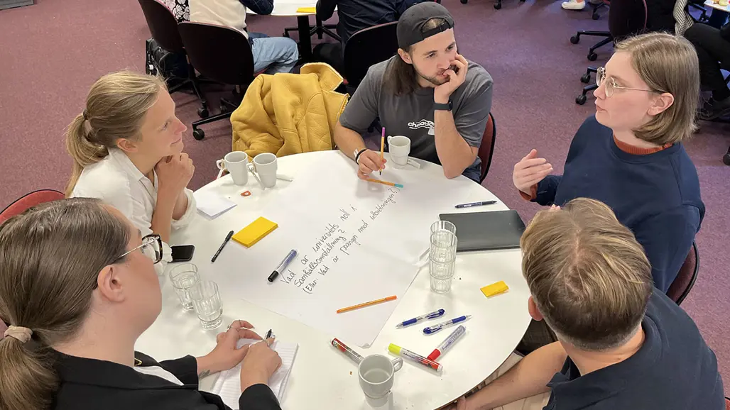 studenter i diskussion vid ett runt bord
