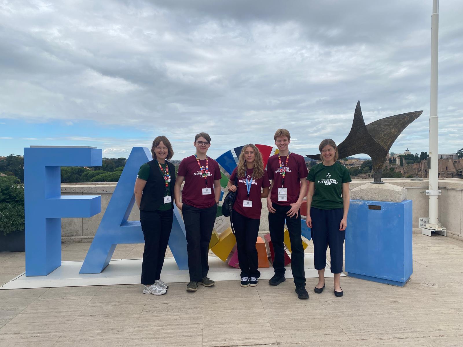 A group posing in front of a sign