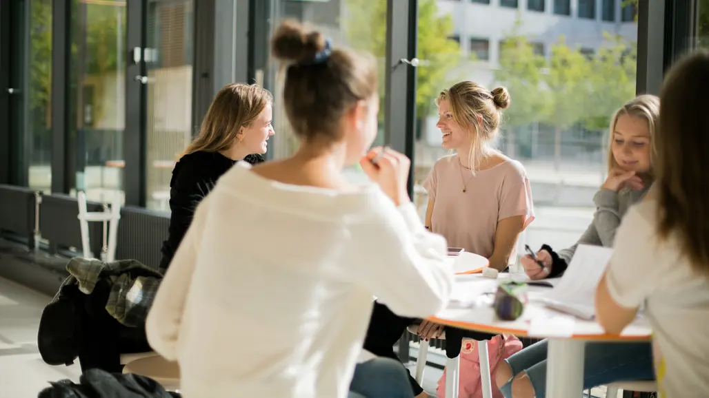 Students gathered at a table and engaged in discussion