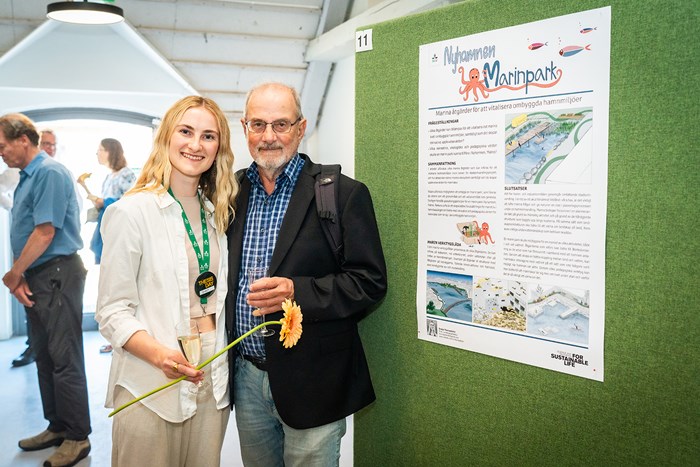 Student och besökare vid posterutställningen. Fotgraf Joe Miller