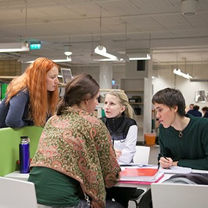 En grupp studenter sitt och pluggar i biblioteket, foto. 